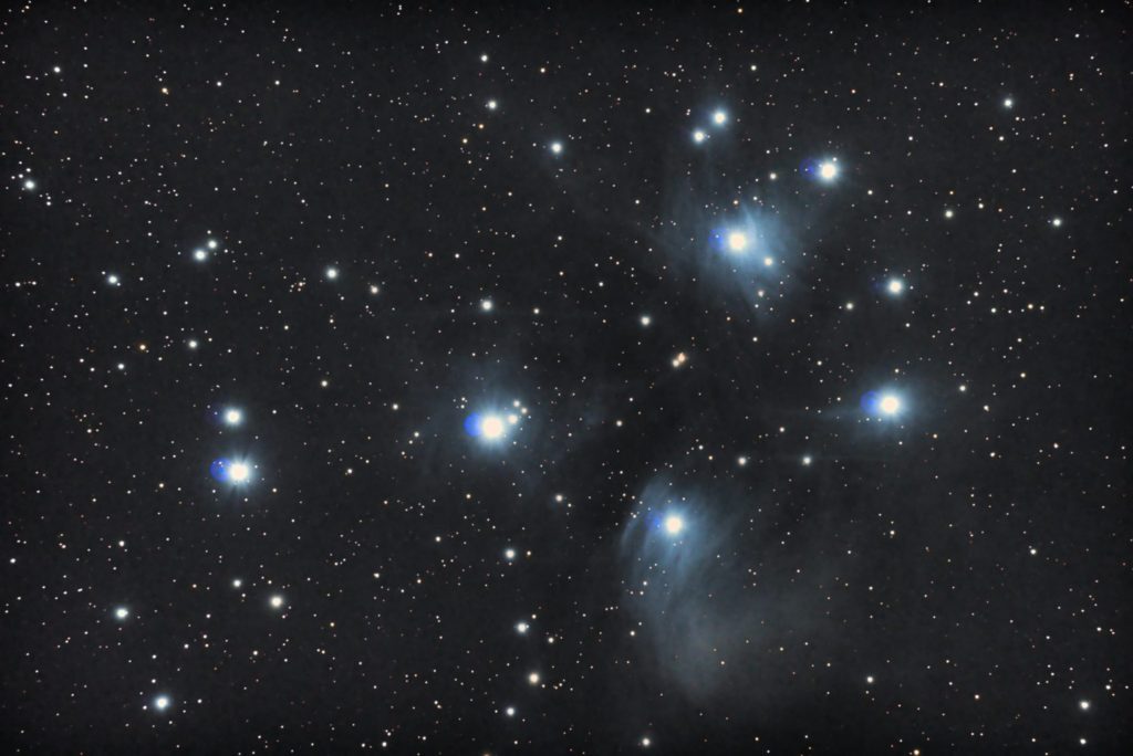 この散開星団の天体写真は2017年10月27日00時15分54秒から撮影した「おうし座」にあるプレアデス星団（すばる/M45/メシエ45）と言う天体です。 使用機材はミード「LXD-55」（口径15cm/F5/シュミットニュートン式反射望遠鏡）と一眼レフカメラのリコー「PENTAX KP」。 ISO51200/F5/露出25秒/24枚加算平均コンポジット。焦点距離はフルサイズ換算約1191mmです。